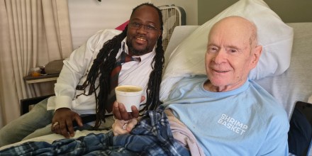 Donell Stallworth brings Charlie Hicks a cup of gumbo at the hospital.